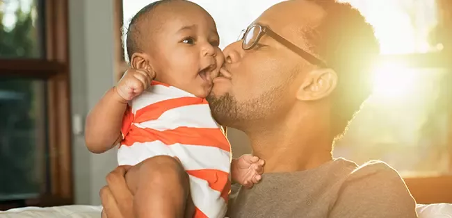 Dad kissing baby